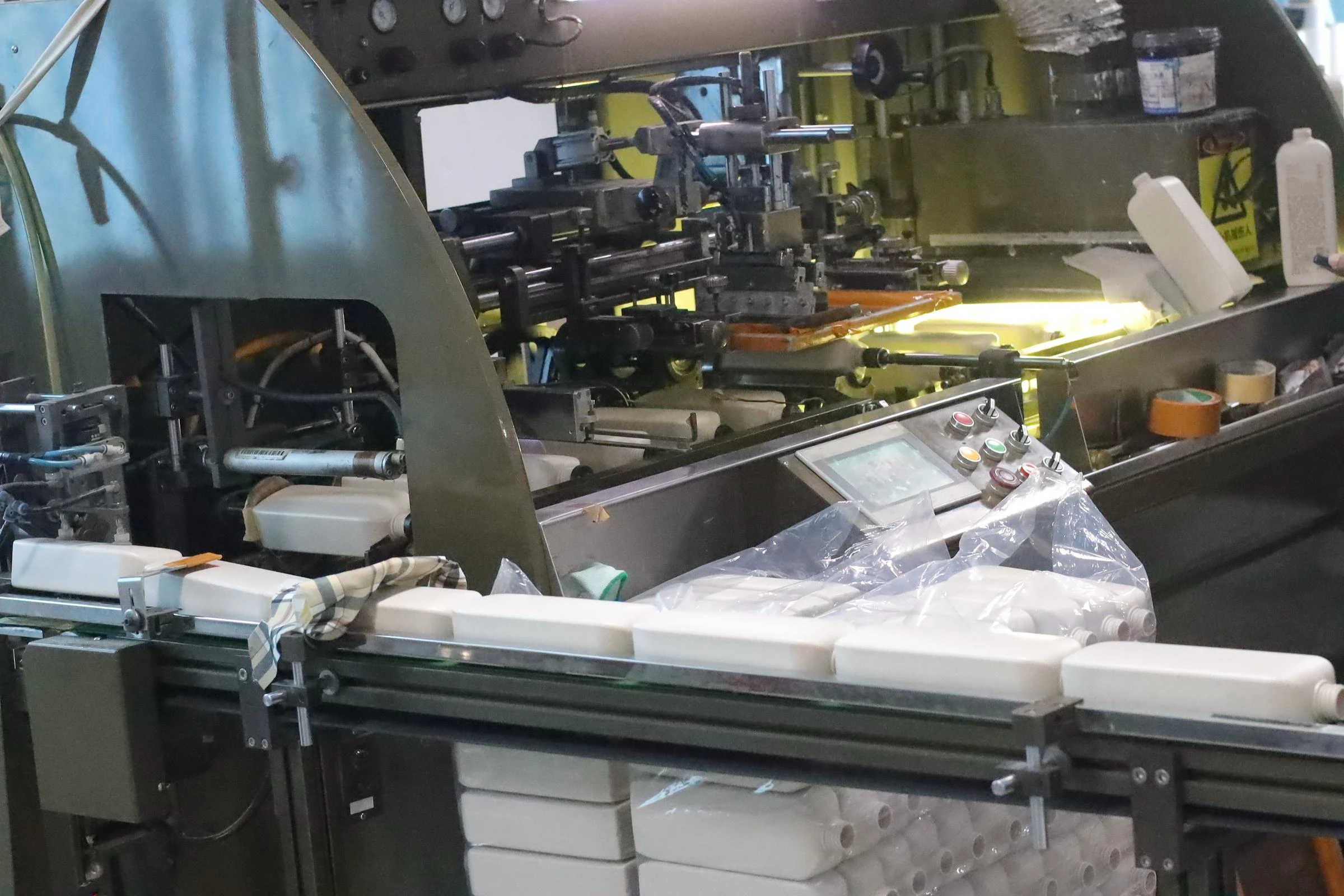 White bottle bodies moving through WDPACK equipment